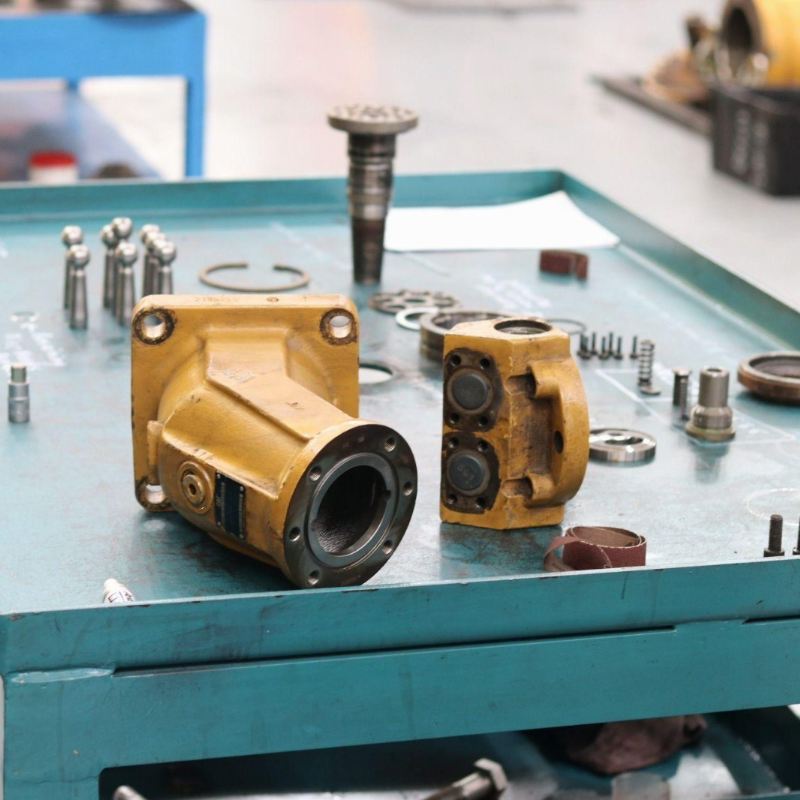 Dismantled hydraulic pump components laid out on the bench for precision cleaning